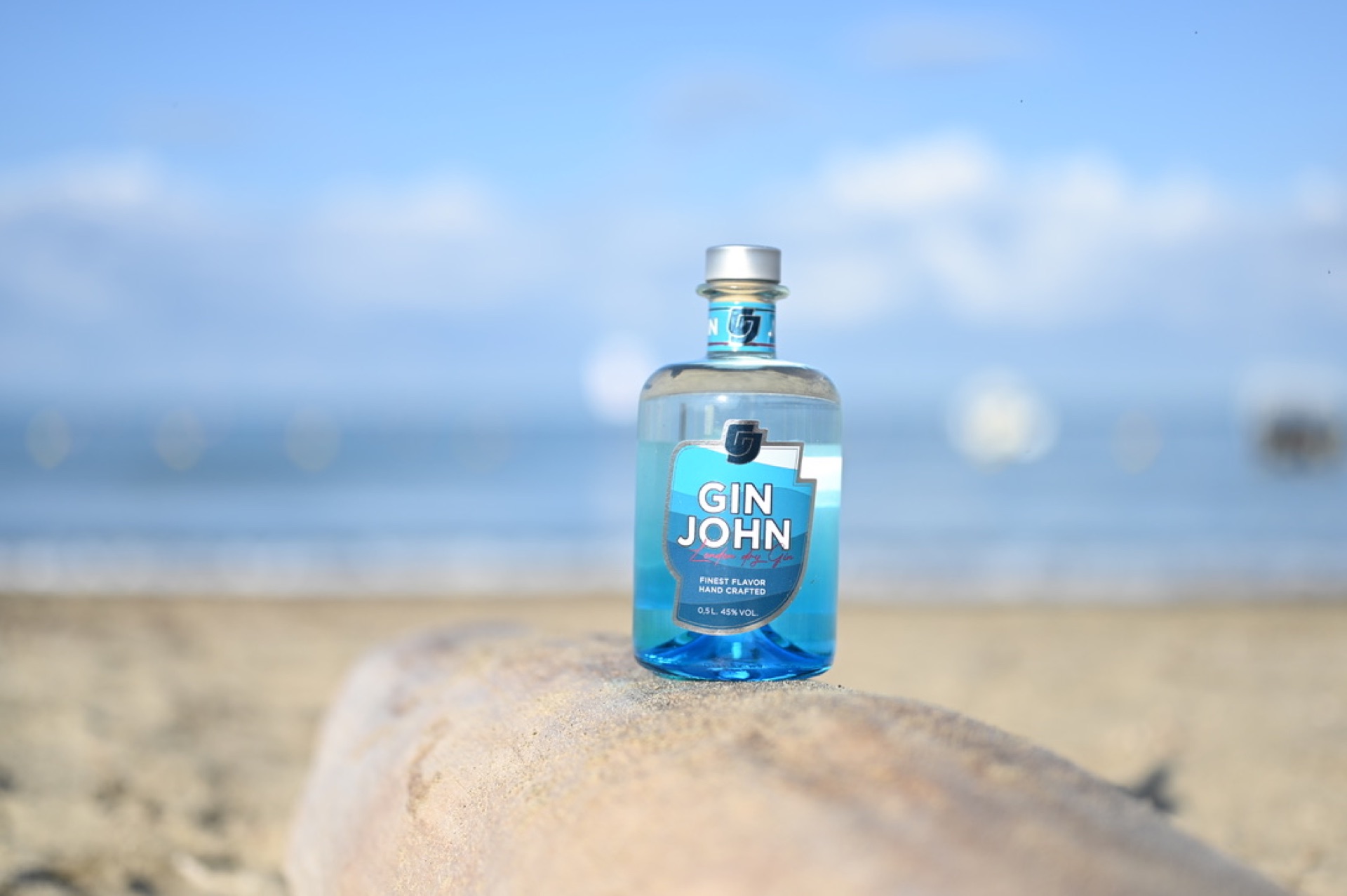 Gin John Flasche im Sonnenuntergang am Strand